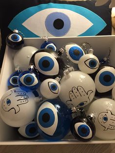 a box filled with lots of blue and white christmas ornaments in front of an evil eye pillow