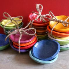 a pile of colorful bowls sitting on top of a wooden table