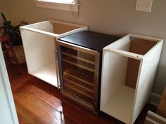 an empty wine cooler sitting in the corner of a room next to a wooden floor