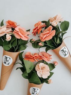 three cones filled with flowers on top of a table