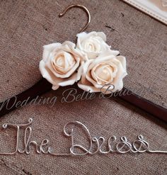 the bride's hanger has flowers on it and is made out of wood