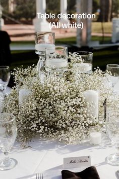 the table is set with white flowers and candles