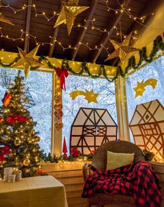 a decorated christmas tree sitting in front of a window next to a lit up christmas tree