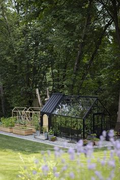 an outdoor play area in the middle of a yard with purple flowers and green grass