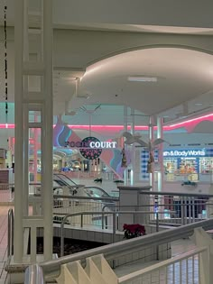 the interior of a shopping mall with escalators and railings leading to shops