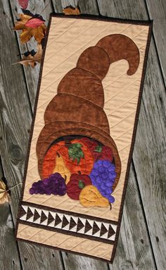 a quilted table runner with a gnome's hat on it and autumn leaves