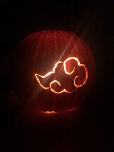 a carved pumpkin with the shape of a dog on it's face in the dark