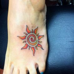 a woman's foot with a colorful sun tattoo on the top and bottom of it