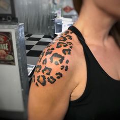 a woman with a tattoo on her arm that has a cheetah print on it