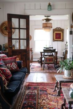 a living room filled with furniture and lots of rugs on the floor next to a doorway