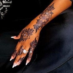 a woman's hand with henna tattoos on it