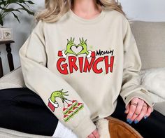 1- Description Welcome to our shop and thank you for choosing us. Our priority is customer satisfaction and we are pleased to offer you high quality products Our products are made of super soft fabrics. Solid colors are 90-100% cotton and heather ones are cotton-polyester blend. 🎄 Spread festive laughs with this "Mommy Grinch" personalized Christmas sweatshirt! Featuring a funny Grinch-inspired design with customizable name ornaments on the sleeve, this cozy sweater is perfect for moms who love a playful holiday look. Ideal for matching family outfits, holiday gatherings, or as a thoughtful gift, this sweatshirt adds humor and warmth to the season. Crafted from soft, high-quality fabric, it's designed for all-day comfort. 🎅 Ready-to-ship within 3 days and sustainably packed, this unique Mommy And Me Christmas Sweatshirts, Grinch Day, Name Ornaments, Funny Grinch, Christmas Custom, Custom Kids, Kids Names, Green Sweatshirt, Custom Shirt