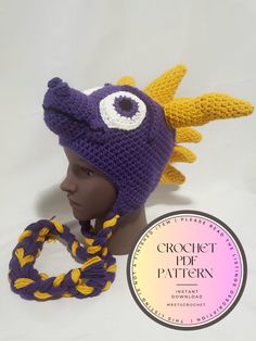 a crochet hat with an eyeball on it and a braid around the brim