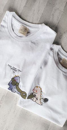 two white tshirts with cartoon animals on them