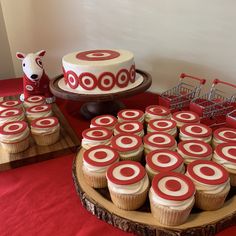 cupcakes are arranged on wooden trays with red and white icing in the shape of circles