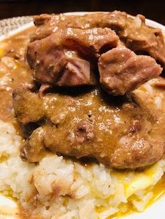 meat and gravy on top of mashed potatoes with gravy over them