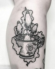 a black and white image of a cup with birds in it on the leg tattoo