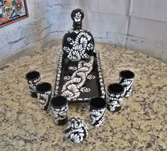 black and white vases sitting on top of a counter