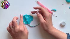 two hands are working on an ornament with blue and white polka dot designs