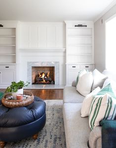 a living room filled with furniture and a fire place in the middle of the room