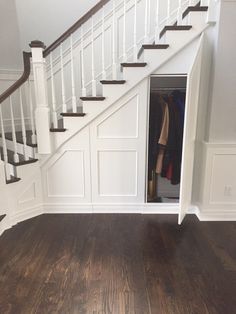 an open closet under the stairs in a house with wood flooring and white walls