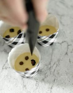 a person cutting into some food in small cups