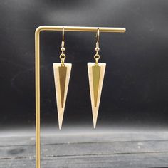 "These marbled white and gold dangle earrings feature 1/4\" wide by 1-3/8\" flat raw brass triangle/spike charms layered over 49mm x 13.5mm acrylic acetate inverted triangle charms.  These earrings measure approximately 2 7/8 inches from the top of the teardrop to the bottom of the white charm, and are incredibly lightweight, weighing just 0.1 ounce combined!  These earrings are available in other colors as well! The green version of these earrings is available here: https://www.etsy.com/listing/719446142/geometric-green-and-gold-layered And the black version is available here: https://www.etsy.com/listing/734899953/geometric-black-and-gold-layered Domestic shipping is always free here at Mayamadethis! When will my item ship?  Every single item here at MayaMadeThis is made to order, meanin White Acrylic Earrings, Inverted Triangle, Gold Dangle Earrings, Earrings Geometric, Silver Spring, White Earrings, White Acrylic, Gold Earrings Dangle, Acrylic Earrings