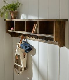 a wooden shelf holding two books and a tote bag hanging from it's side