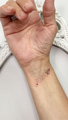 a woman's arm with a small tattoo on it, and the word love written in