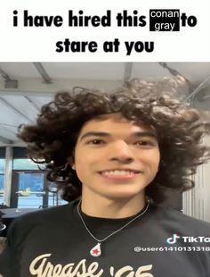 a young man with curly hair smiling at the camera while wearing a t - shirt that says, i have tried this gray to stare at you