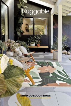 an outdoor rug is shown in front of a house with potted plants on the porch