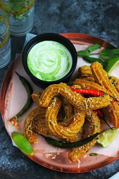 an assortment of food on a plate with dipping sauce