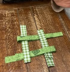 someone is making a cross out of green paper