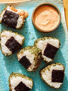 sushi rolls on a blue plate with dipping sauce