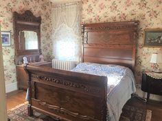 a bed sitting in a bedroom next to a wooden dresser and mirror on top of a hard wood floor