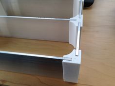 a close up view of the bottom part of a shelf with metal brackets on it