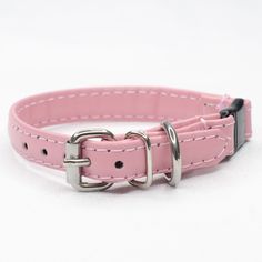 a pink dog collar with silver buckles on it's sides and a white background