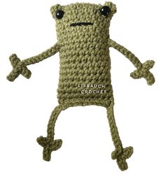 a crocheted cell phone case with eyes and arms is shown in the shape of a frog