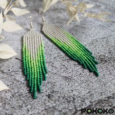 green and white seed beaded earrings on grey background