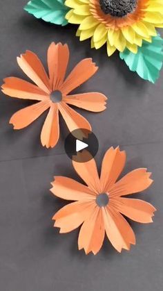 some paper flowers are laying on the ground next to each other with one flower cut out