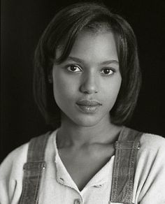 a black and white photo of a woman in overalls with her hands on her hips