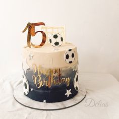 a birthday cake decorated with soccer balls and the number fifteen on it's top