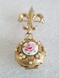 "Featuring this 1945-1950's Coro Pegasus Chatelaine Brooch w/4 pop up picture frames. On the top part is a Fleur-De-Lis shaped brooch and at the bottom dangles a pocket watch shaped like that has 4 pop up pictures. Each picture is uniquely stacked inside the pocket watch locket with old photos and instructions. On the backside is the hallmark Coro with the Pegasus to the left side and Patent Pending #2545267. After closing the pocket watch on the front side is a beautiful, enameled Pink Rose wit Vintage Medallion Brooch For Wedding, Vintage Medallion Brooches For Wedding, Vintage Collectible Enamel Pin, Vintage Medallion Brooches For Formal Occasion, Vintage Style Formal Brooch Enamel Pin, Vintage Formal Enamel Pin Brooch, Vintage Enamel Wedding Brooches, Vintage Enamel Brooches, Pop Up Picture