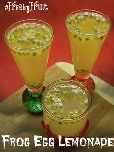 three glasses filled with liquid sitting on top of a wooden table next to each other