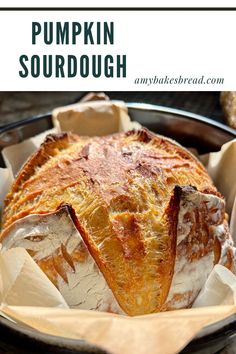 pumpkin sourdough in a black bowl with parchment paper on the side and text overlay that reads, pumpkin sourdough