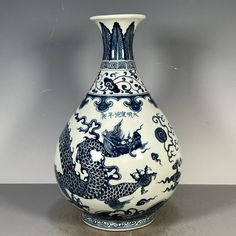 a blue and white vase sitting on top of a table next to a gray wall