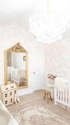 a baby's room with a crib, dresser and mirror in the corner