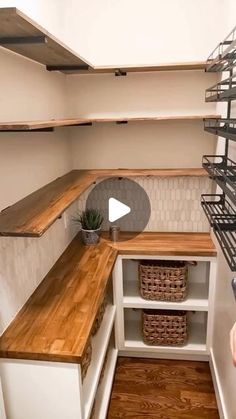 an empty pantry with shelves and baskets on the counter, in front of a person holding a camera