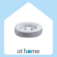 a dog bed with the words at home on it and an image of a house in the background