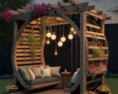 an outdoor seating area with hanging lights and potted plants on the side of it